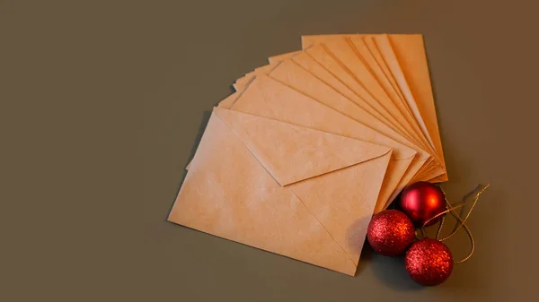 Composición navideña. Sobres artesanales y bolas rojas — Foto de Stock