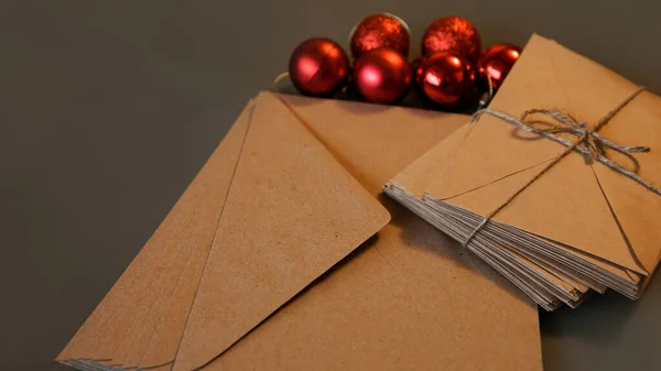Vánoční kompozice. Craft obálky a červené koule — Stock fotografie