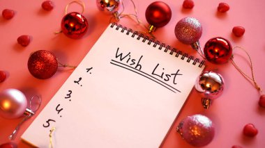 Pembe arkaplanda noel topları olan bir defter.