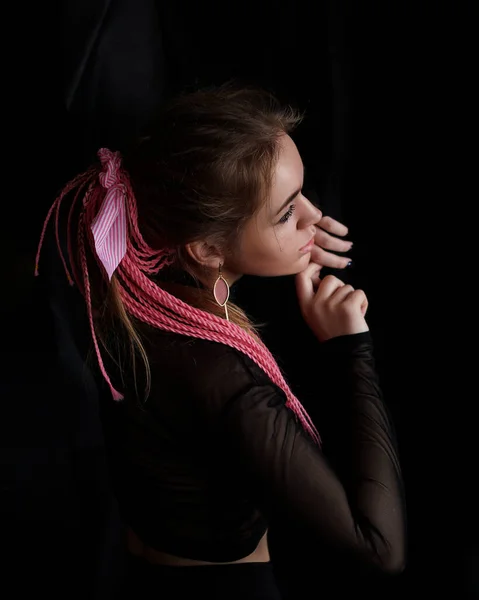 Uma menina bonita com rosa afro ou zizi tranças em um fundo preto — Fotografia de Stock