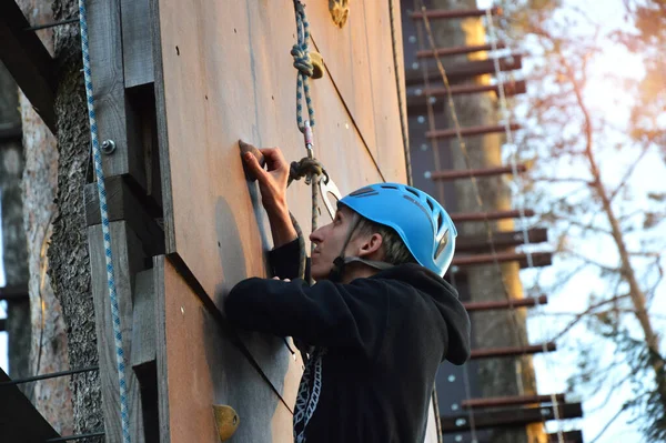 Young man climbing wall rock outdoors — Stock Photo, Image