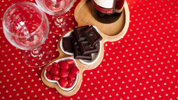 Chocolates and sweets on heart-shaped plates. Festive table setting for date — Stock Photo, Image