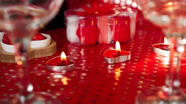 Свечи на день Святого Валентина, стол с праздничным красным фоном — стоковое фото