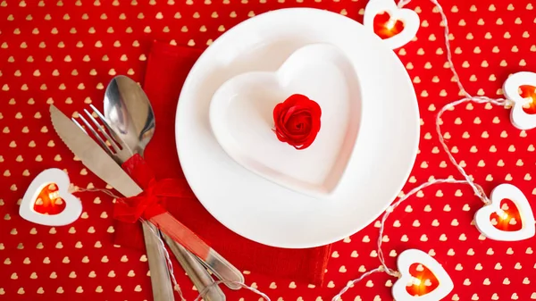 Un piatto bianco con coltello e forchetta su fondo rosso vivo — Foto Stock