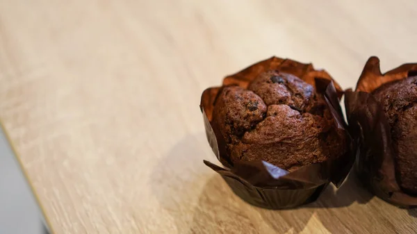 Dois muffins de chocolate na mesa de madeira — Fotografia de Stock
