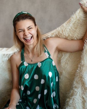 İki arkadaş kanepede uzanıp sohbet ediyorlar. Sarışın, elinde bir kadeh şarap tutuyor.