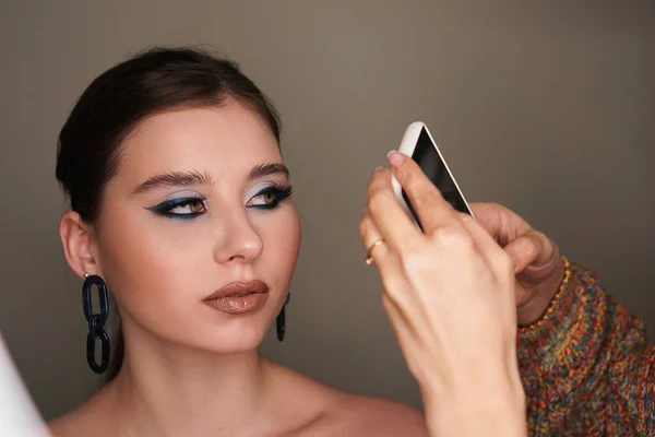 Make up artist taking mobile photo for the model with makeup — Stock Photo, Image