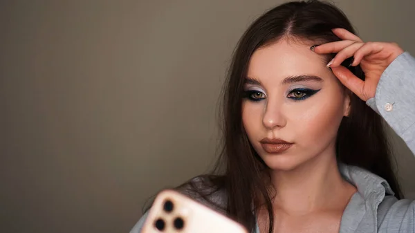 Молодая привлекательная модель делает селфи после макияжа в студии красоты — стоковое фото