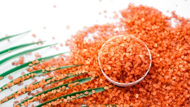 Beyaz arka planda turuncu deniz tuzu. Tropik palmiye yaprakları