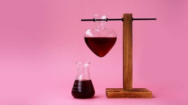 Sevgililer günü iksiri. Pembe arka planda kalp şeklinde bir aşk iksiri