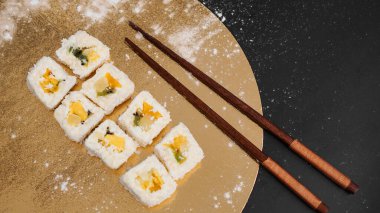 Sushi teslimatı. Pirinç, ananas, kivi ve mangodan yapılmış börekler..