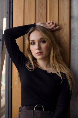 Tahta pencere eşiğinde seksi bir sarışın. Evdeki güzel kız.