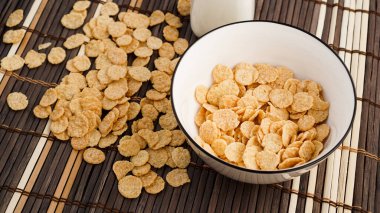 Bambu peçetesinde sağlıklı mısır gevreği ve süt. Sağlıklı bir kahvaltı için bir şişe süt.