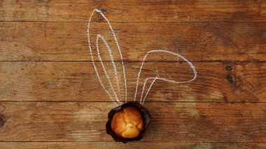 Ahşap arka planda kulakları olan lezzetli paskalya çörekleri. Kulaklar tebeşirle çizilir. Mutlu Paskalya tebrik kartları ve afişler.