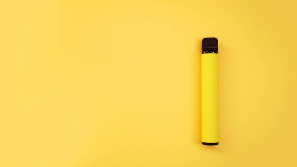 Yellow disposable electronic cigarette on bright yellow background