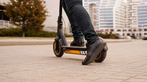 Zugeschnittenes Bild eines jungen Mannes, der auf der Straße auf einem Elektro-Tretroller fährt — Stockfoto