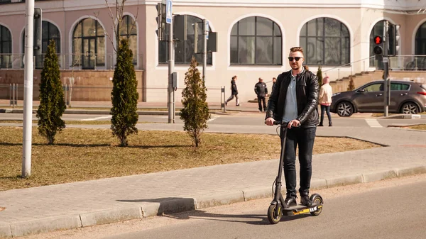 Modern man riding electric scooter in the city