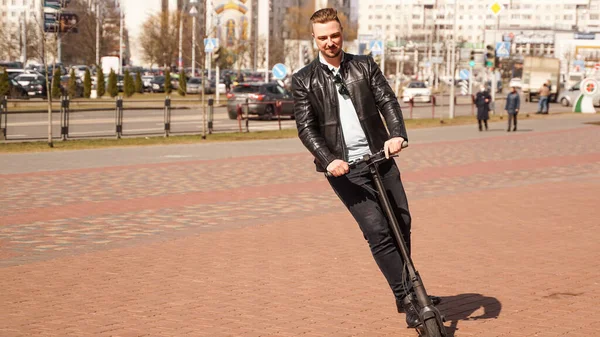 Modern man riding electric scooter in the city