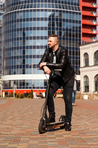 Innovative transport. Glad optimistic guy leaning on electric scooter