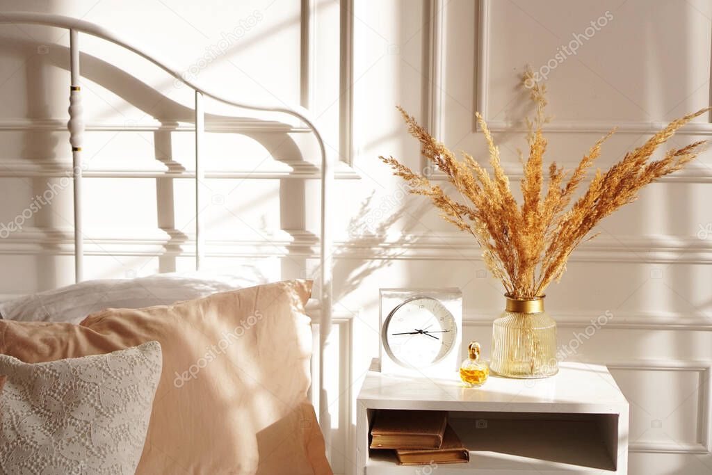 White Scandinavian bedroom in sunshine. Beige accessories