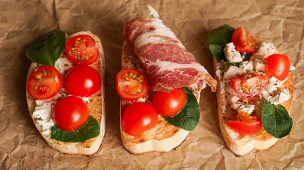 El işi kağıdında üç taze bruschetta. Lezzetli çerez. Yukarıdan görüntüle