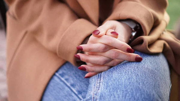 膝に赤いマニキュアが付いた女性の手。待つという概念 — ストック写真