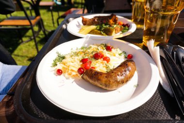 Tabakta salatalı sosis ve tepside hafif bira. Sokak yemeği.