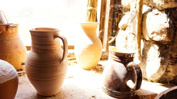 Vecchia pentola di argilla in una vecchia stanza. Vecchi scaffali polverosi in un laboratorio di ceramica. — Foto Stock