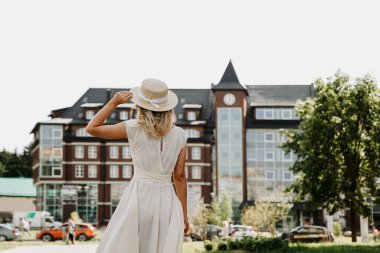 Bir Avrupa şehrinde hasır şapkalı, mutlu bir kadının arka planı..