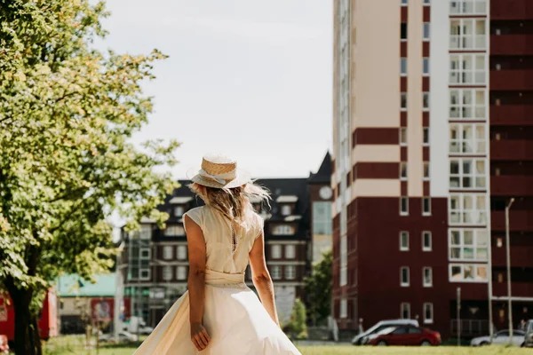 Vue arrière d'une jeune femme heureuse dans un chapeau de paille dans une ville européenne. — Photo