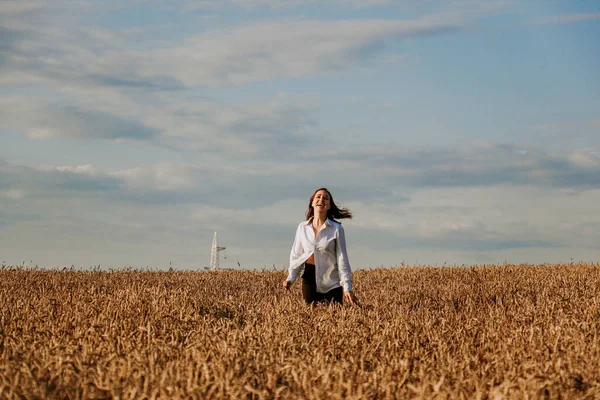 Mutlu kadın bir yaz günü buğday tarlasında koşar. Mutluluk ve neşe kavramı — Stok fotoğraf