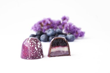 Beyaz arkaplandaki kesikte çikolata şekeri. Yabanmersini ve lavanta