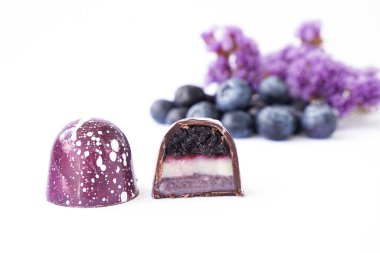 Beyaz arkaplandaki kesikte çikolata şekeri. Yabanmersini ve lavanta