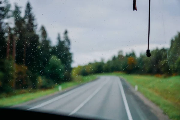 雨の水が窓に落ちる。道路の眺めと秋の森 — ストック写真