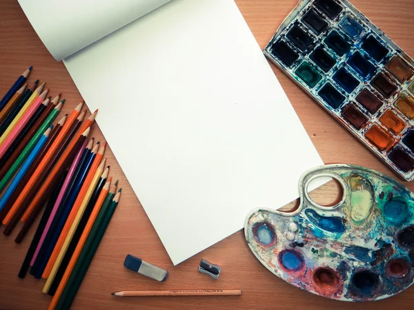 Strumenti da ufficio, matite colorate e acquerello sul tavolo — Foto Stock
