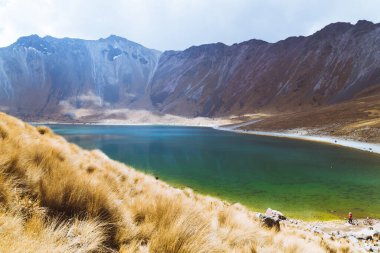 Dağlarla ve mavi gökyüzüyle çevrili kristal bir su gölü..