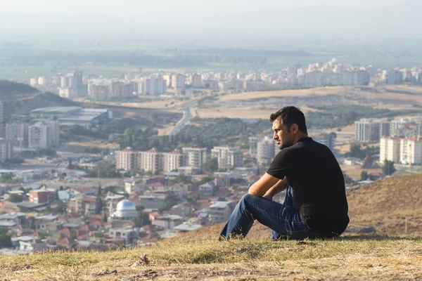 güçlü adam dağın tepesinde şehri seyir siyah giysili