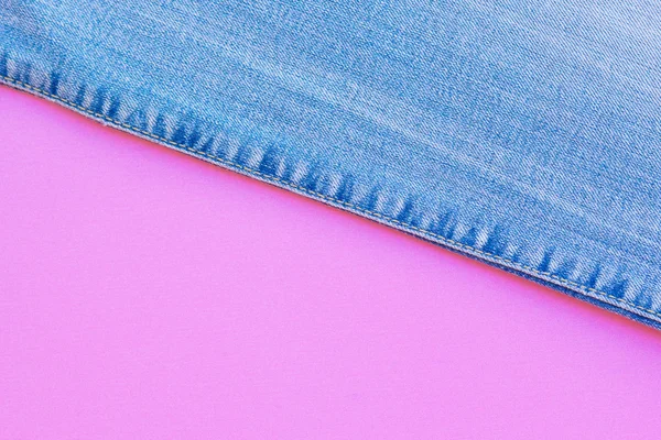 Bakgrunden kombination av blå och rosa. Ovanifrån blå jeans på en rosa bakgrund — Gratis stockfoto