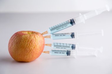 Genetiği değiştirilmiş meyve ve şırınga konsepti