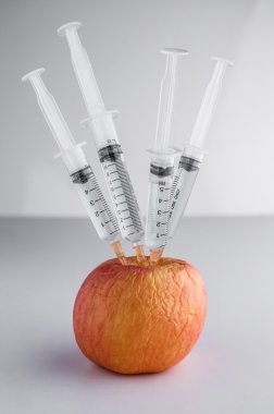 Renkli kimyasal Gm ile genetiği değiştirilmiş meyve ve şırınga