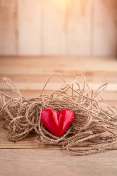 Rött hjärta form med rep på trä skrivbord — Stockfoto