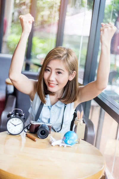 Chica sonriente con cosas de viaje en la cafetería —  Fotos de Stock