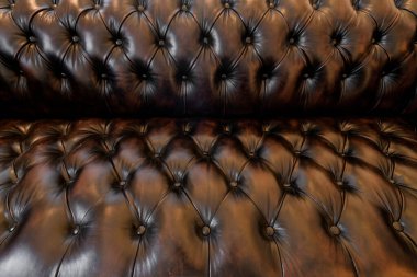 Yakın plan kahverengi deri kanepe düğmesi ve budama tasarımı ile