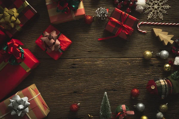 topview flatlay of christmas gift items with red color and ribbon wrap on wooden texture floor with decorative ornament new year and chiristmas festive greeting background ideas concept