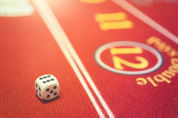 business game concept dice laying over a pile of money on roulette wheel table casino background