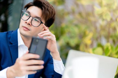 Akıllı iş adamı resmi takım elbisesi rahat otur dizüstü bilgisayarla el ele tutuşup televizyon konferansında uzaktan çalışma sosyal mesafesi ile buluş. Asyalı, bira işi, bahçe parkı arka planında rahatla