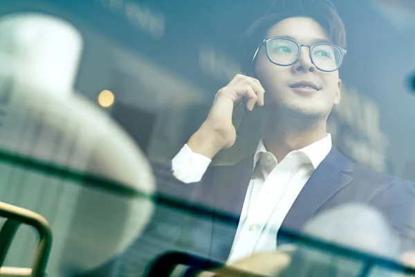 creative agency smart glasses asian male formal cloth conversation with smartphone freelance working with laptop at coworking area office space with freshness with blur office background