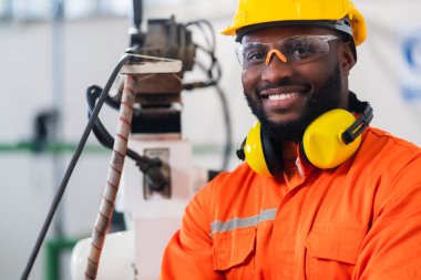 Amerikan yerlilerinin portresi. Güvenli üniforma giyen teknisyen. El yapımı otomasyon robot kolu kaynak makinesi.