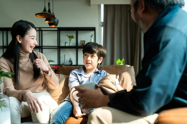 Asian family sit relax positive conversation with son, happiness smile boy casual talking with his parent,Happy Asian family enjoy holiday together at sofa, home sweet home living room