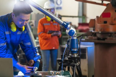 Manipülatör kollu Asyalı kadın mühendis uzmanı. Üç boyutlu koordinat ölçümü. Ölçülerini kontrol et. Parçaların boyutlarını üç boyutlu kontrol et. Makine işleminden sonra CMM